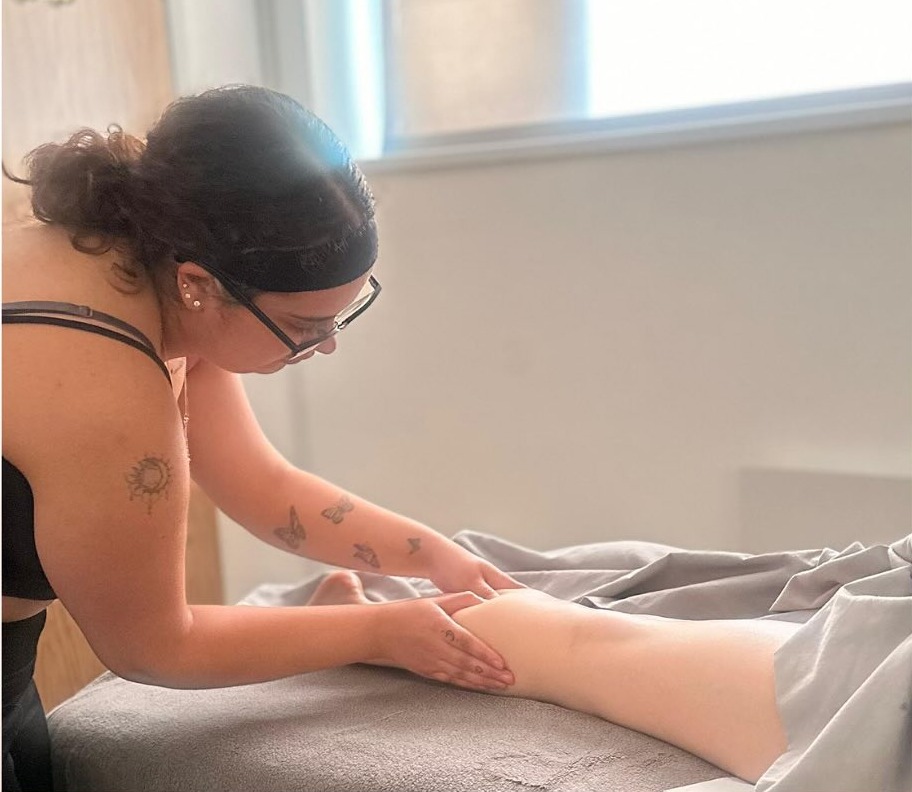Therapist performing a full leg and foot massage in a treatment room at Precious Moments Beauty Clinic, Banstead